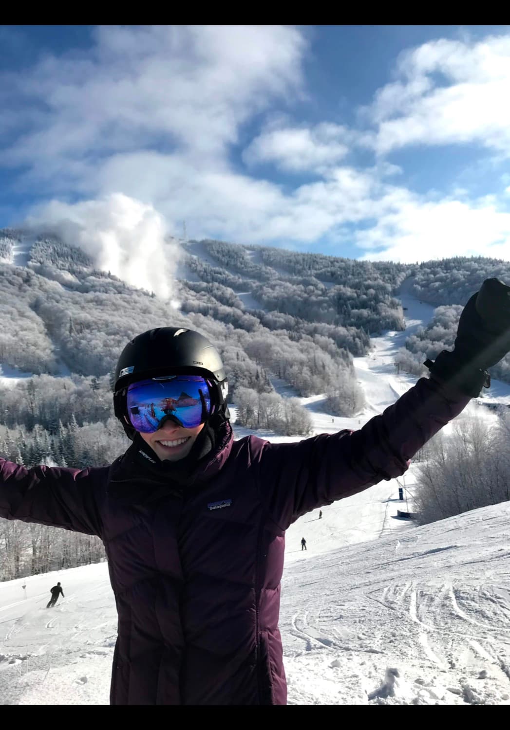 Rebecca skiing in a purple coat, arms raised on a snowy mountain — before her injury.